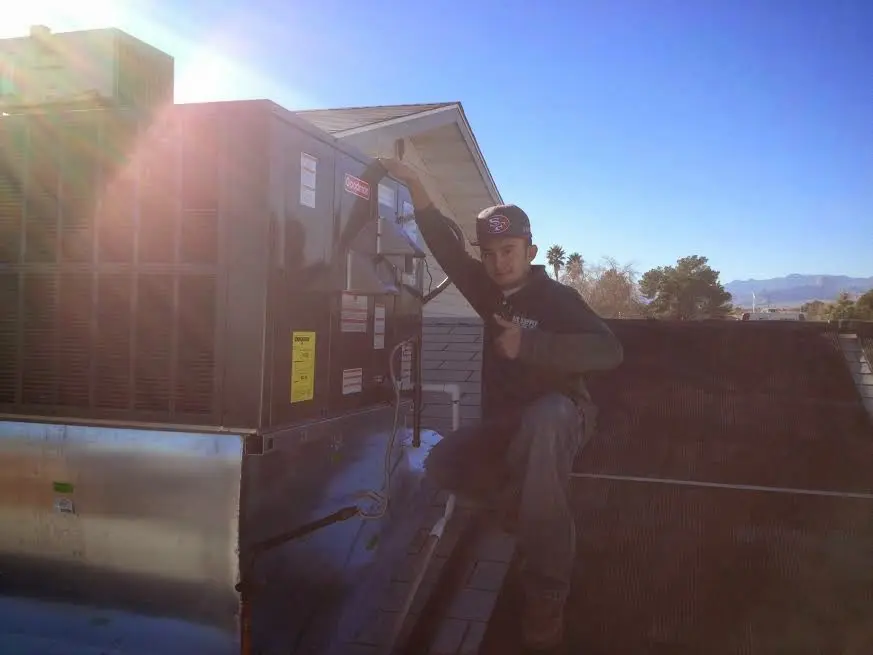 HVAC technician performing Air Duct Cleaning on a rooftop unit in Hapeville